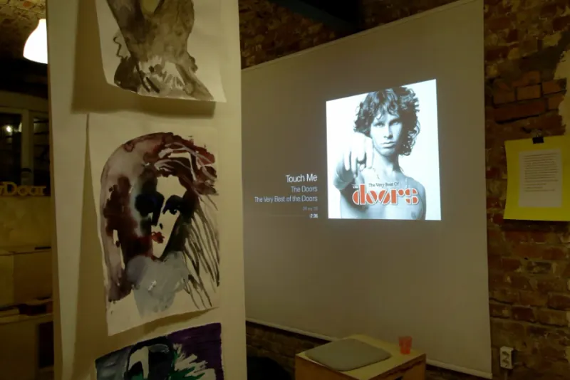 Проекция The Doors рядом с развешанными рисунками